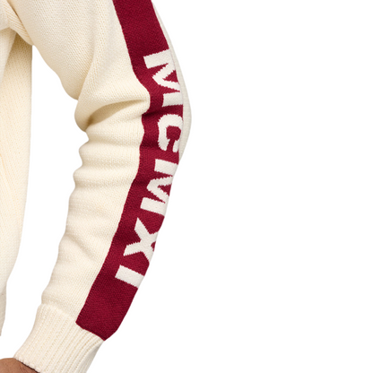 Close-up of a custom fraternity sweater sleeve, showing the text 'MCIMXI' in white on a red background, knitted into the fabric.