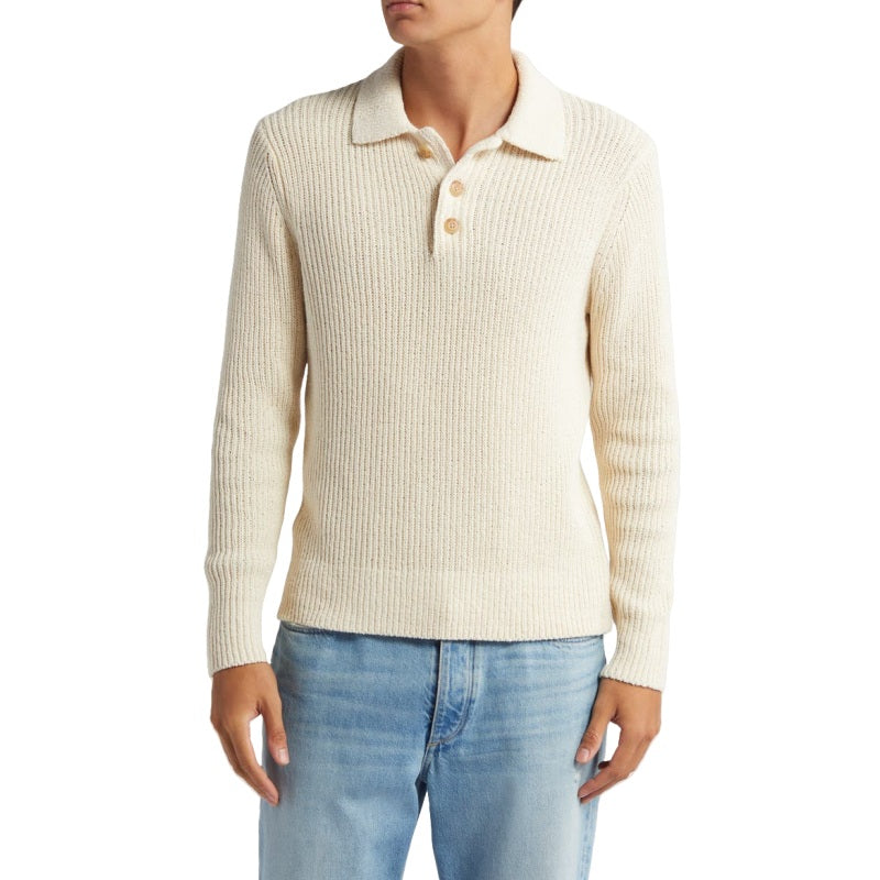 Model wearing a beige 100% cotton knit sweater with a polo collar and three-button placket, showcasing the fit and style of the sweater paired with light blue jeans.