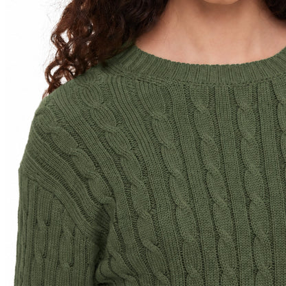 Close-up of cable knit texture on a green sweater