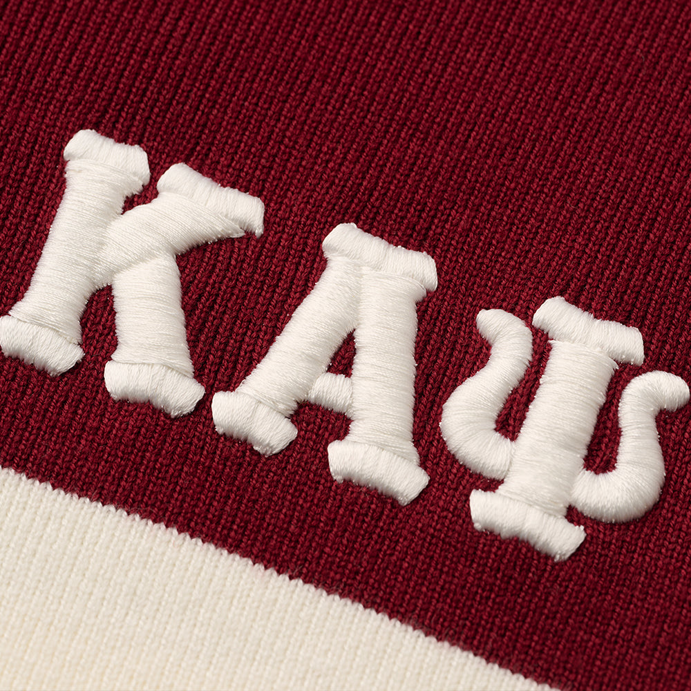 Close-up of embroidery on a maroon and white knit sweater showing the Greek letters Kappa Alpha Psi.