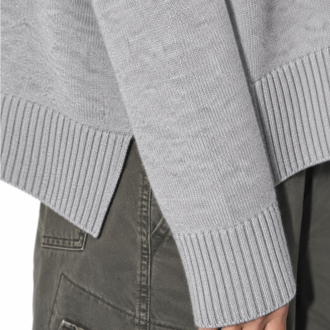 Close-up of the grey sweater's ribbed cuff and hem.
