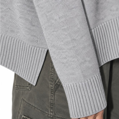 Close-up of the grey sweater's ribbed cuff and hem.