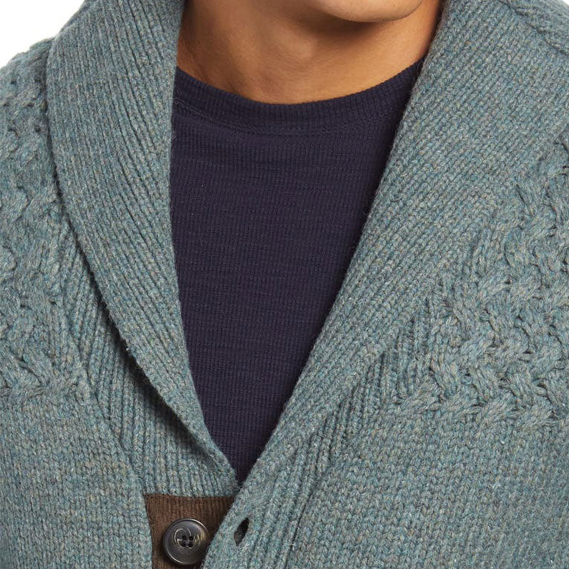 Close-up of the button and collar detail on the custom wool blend cardigan, featuring a textured knit pattern and a brown inner lining.