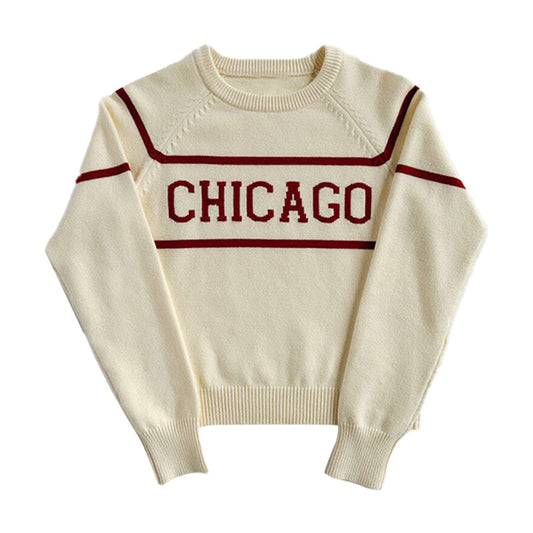 White knit pullover sweater with red horizontal stripes and the word 'CHICAGO' in red across the chest.