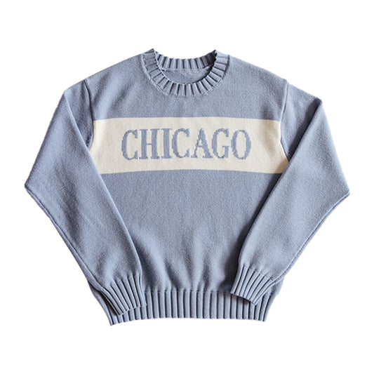 Light blue custom knit sweater with a white stripe across the chest displaying the word 'CHICAGO' laid out flat.