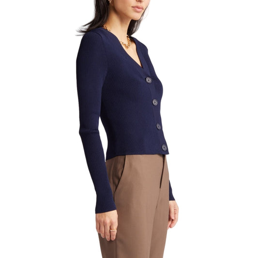 Model wearing a navy blue ribbed cardigan with long sleeves and front button closures, paired with brown trousers. 