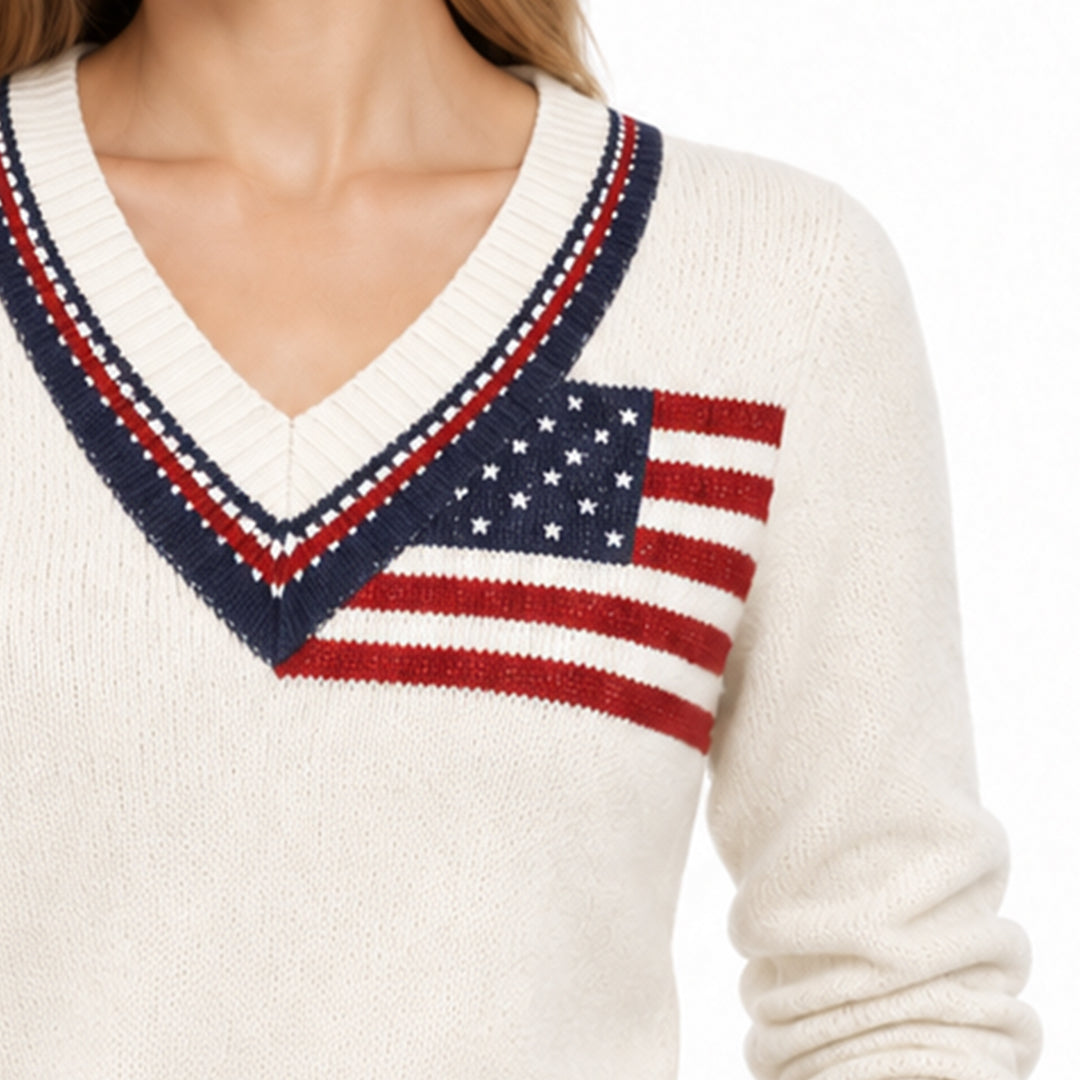 Close-up of cream sweater showing American flag motif and contrast V-neck trim