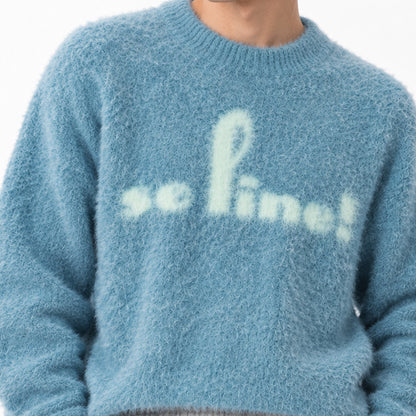 Detail of the script graphic and textured blue knit fabric.