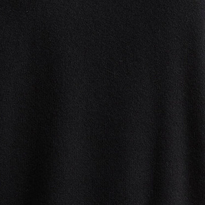 Close-up of the knit texture of a black custom logo sweater, highlighting the 100% cotton material