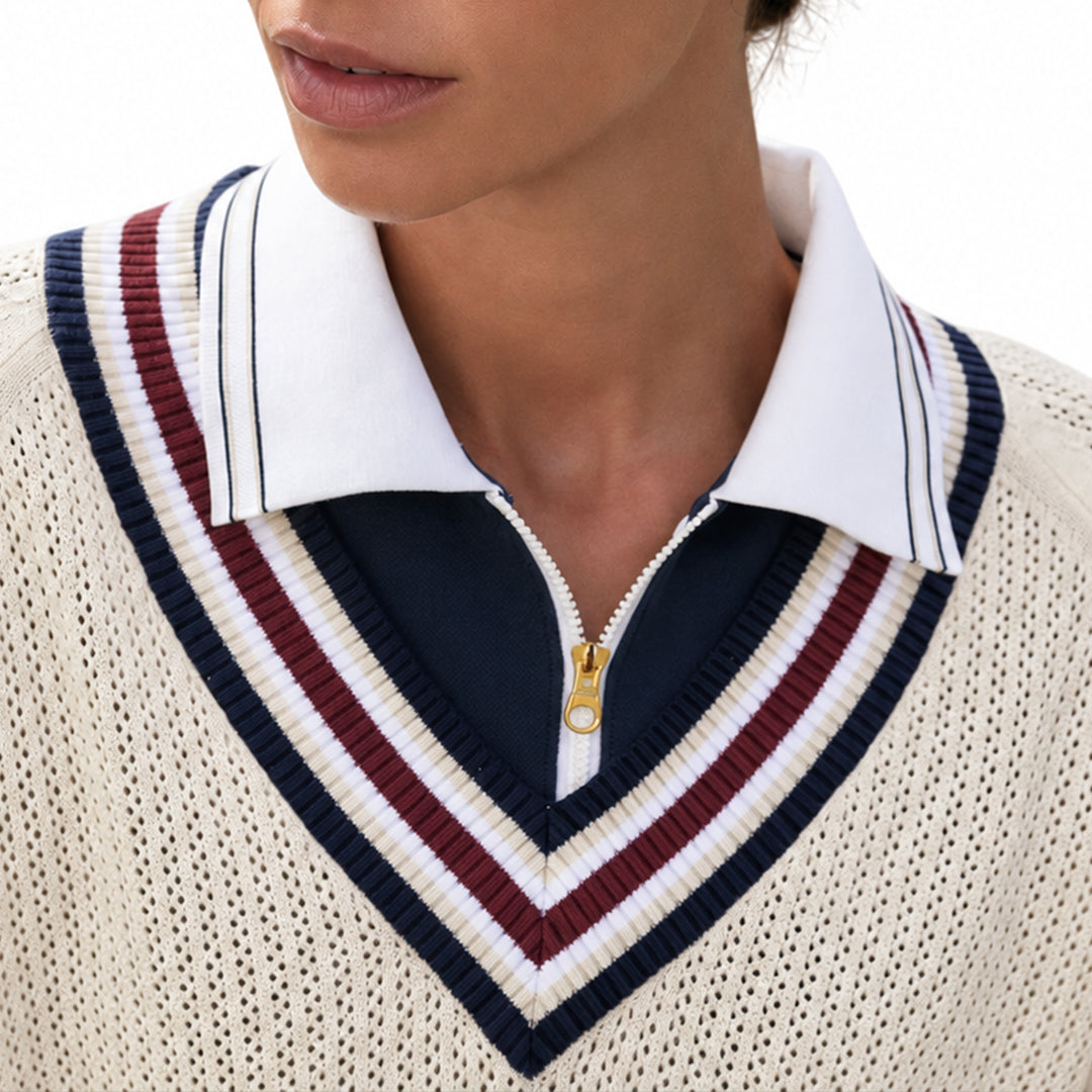 Close-up of the striped V-neck on a cream varsity knit sweater