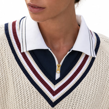 Close-up of the striped V-neck on a cream varsity knit sweater