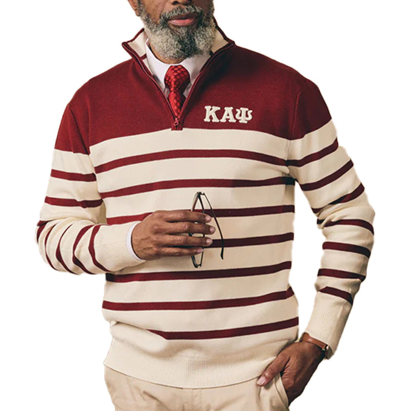 An older gentleman wearing a maroon and white striped custom Greek knit sweater with the text 'KAΨ' on the left chest, holding a pair of glasses.