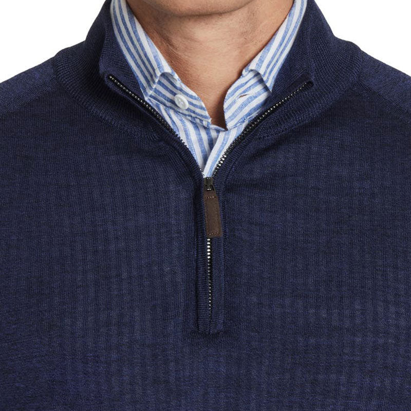 Close-up of the 1/4 zipper polo collar of a custom 100% cotton knit sweater in navy blue, worn over a striped shirt.