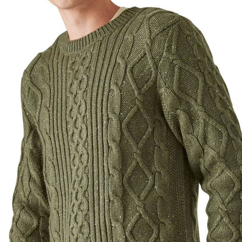 Close-up of the olive green wool blend cable knit pullover sweater, focusing on the intricate cable knit design and the round neck, worn by a smiling man.