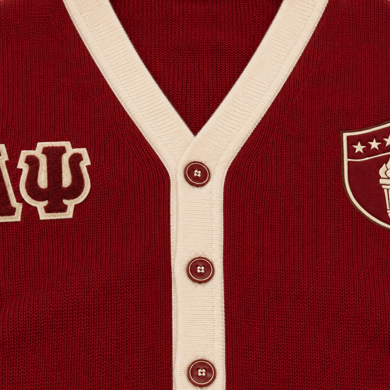 Red knit cardigan with cream V-neck trim, buttons and Greek letter embroidery