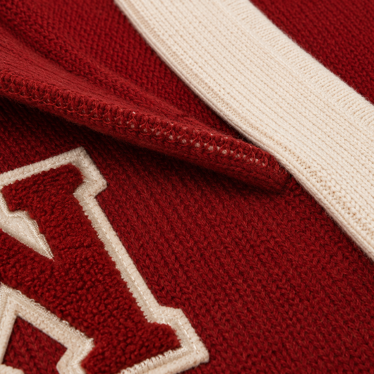 Close-up of red knit texture with embroidered collegiate details