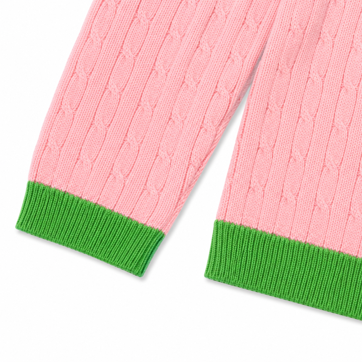 Close-up of apple green ribbed cuffs and hem on a salmon pink knit cardigan