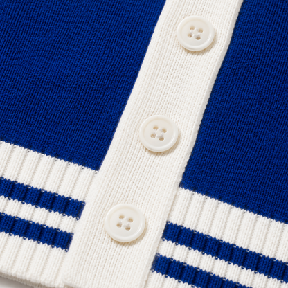  Macro view of royal blue knit texture, white ribbing, button details, and blue stripe construction
