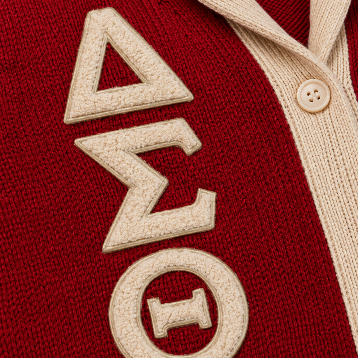 Red custom Greek cardigan featuring embroidered letters, chapter-style crest detail and classic varsity knit structure