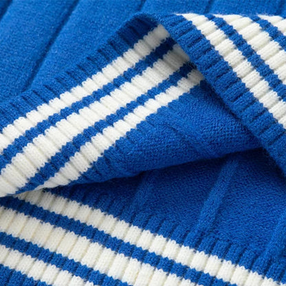 Close-up of Blue Ribbed Knit Sweater Fabric with Cream Striped Detailing, Highlighting the Texture and Quality of the Material.