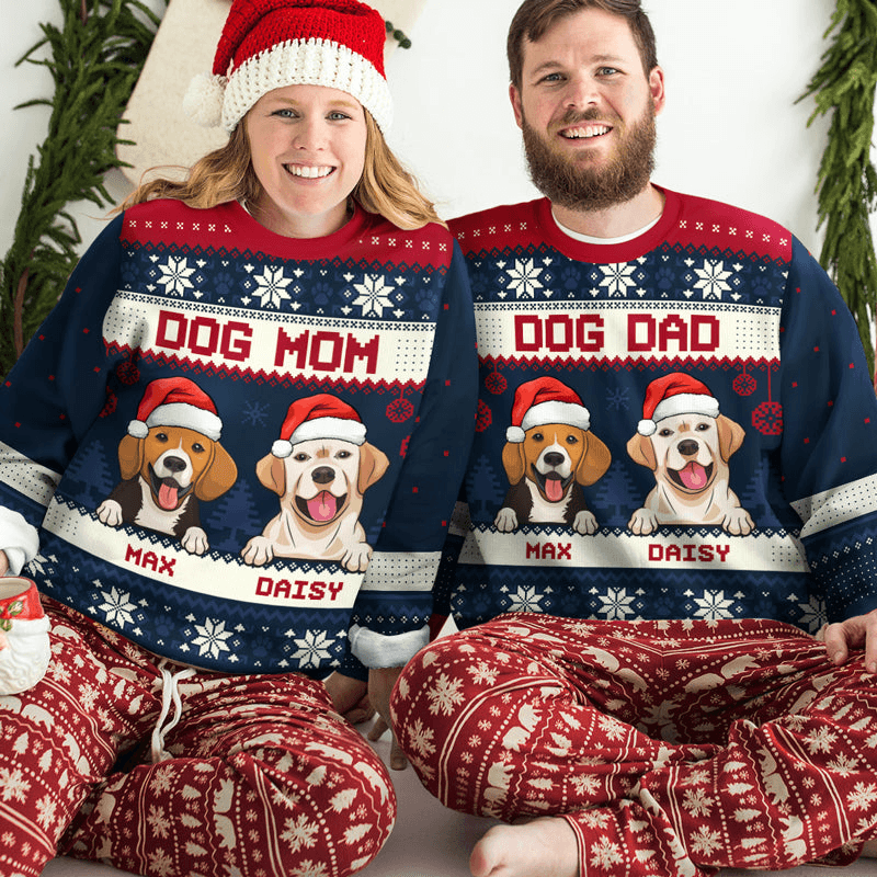 A smiling couple wearing matching custom cute dog jacquard sweaters with "Dog Mom" and "Dog Dad" designs, featuring cartoon dogs named Max and Daisy. They are sitting together in festive pajamas.