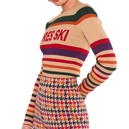 Side view of rib knit sweater showing colorful striped sleeves and matching patterned knit pants.