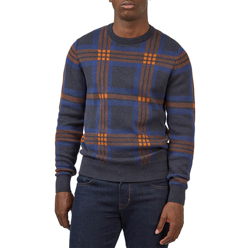 Front view of a man wearing a custom cotton blend knit sweater with a jacquard geometric figure design in navy blue and orange.