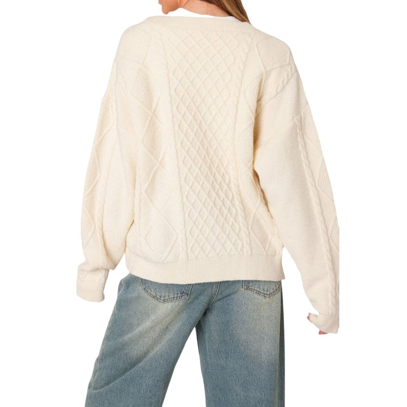 Custom wool blend knit sweater in cream color, highlighting the cable knit patterns and relaxed silhouette.