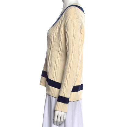 Side view of a cream-colored 100% cotton women's knit pullover sweater with a V-neck, navy blue accents, and cable knit pattern.