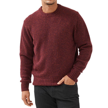 Man wearing a maroon wool blend knit sweater with ribbed cuffs and hem, showcasing the front view and fit of the garment.