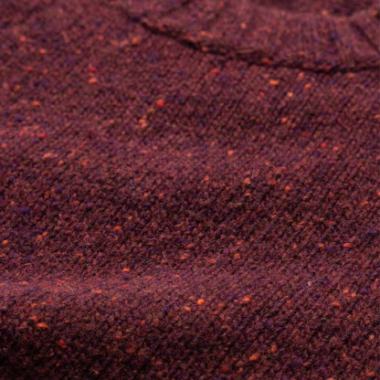 Close-up of the maroon wool blend knit sweater fabric, focusing on the texture and flecked detail.