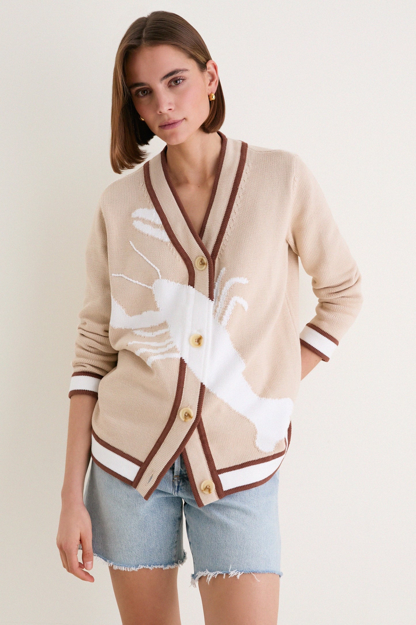 Front view of casual knitted cardigan with graphic pattern and button closure.