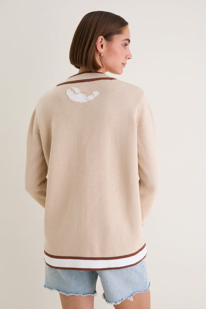 Back view of beige knit cardigan with simple design and contrast hem detail.