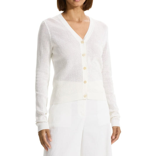 Front view of a woman wearing a custom crochet acrylic knit sweater in white. The cardigan features a V-neckline, button-front design, and long sleeves, paired with white pants.