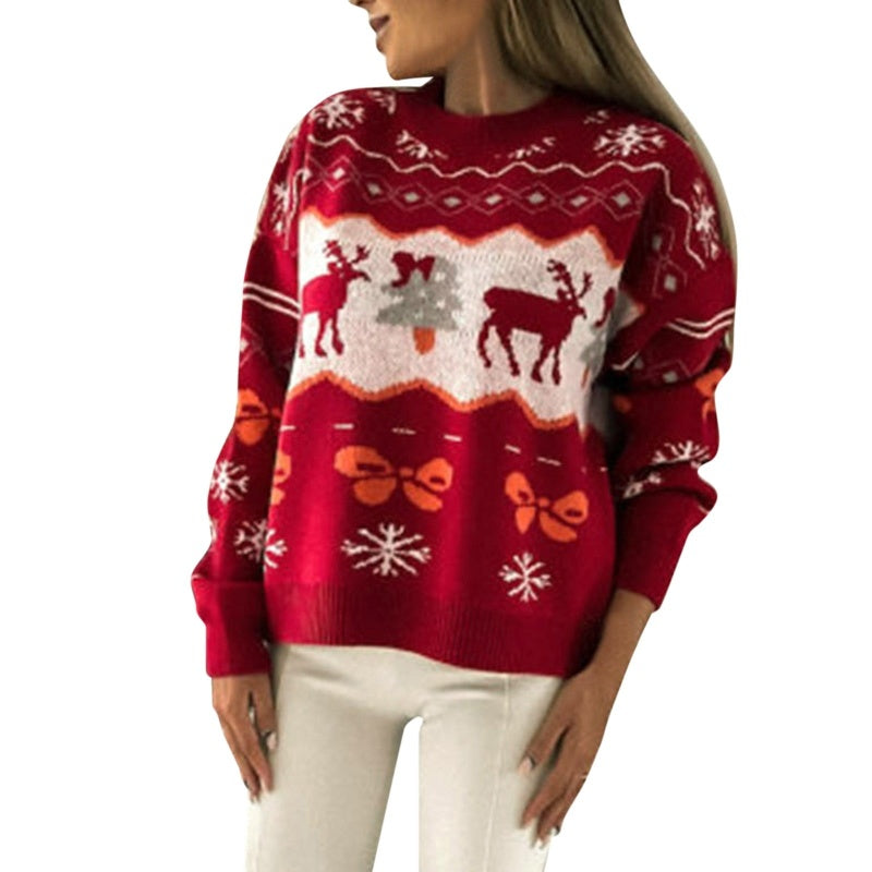 Front view of a woman wearing a red knit cotton Christmas sweater featuring reindeer, Christmas trees, and snowflakes in a festive design.