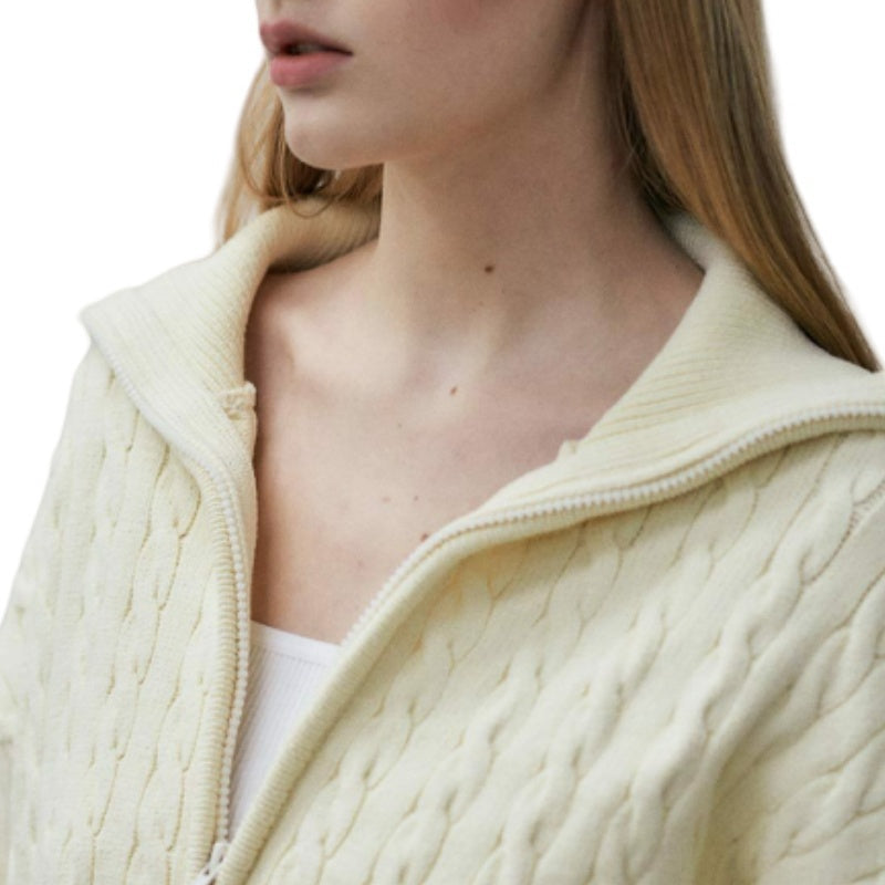 Close-up of a woman wearing a custom wool blend zipper cardigan, highlighting the intricate cable-knit patterns and the quality of the fabric.