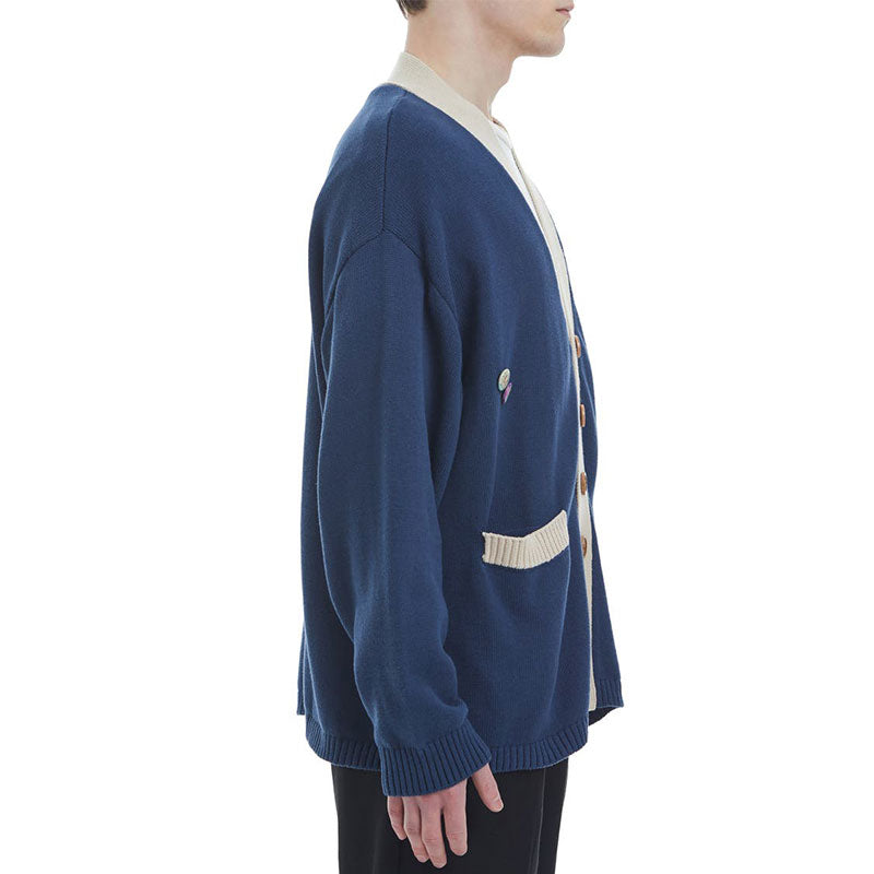 Model wearing a blue 100% cotton varsity cardigan with V-neck, side view.