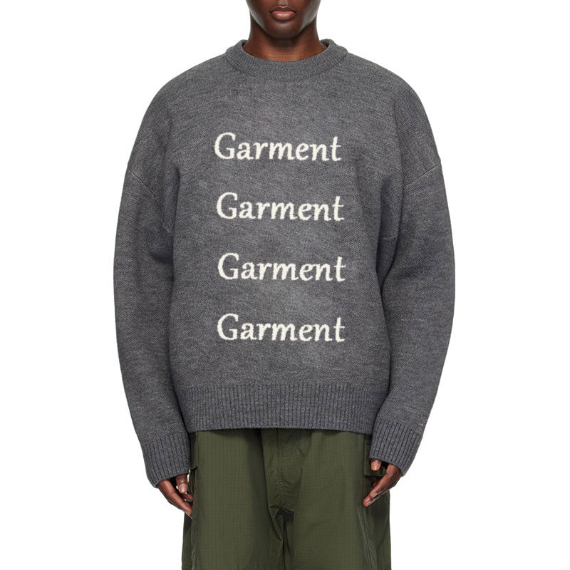 Front view of a custom gray jacquard knit sweater featuring bold 'Garment' lettering repeated down the front, designed with a relaxed, oversized fit.