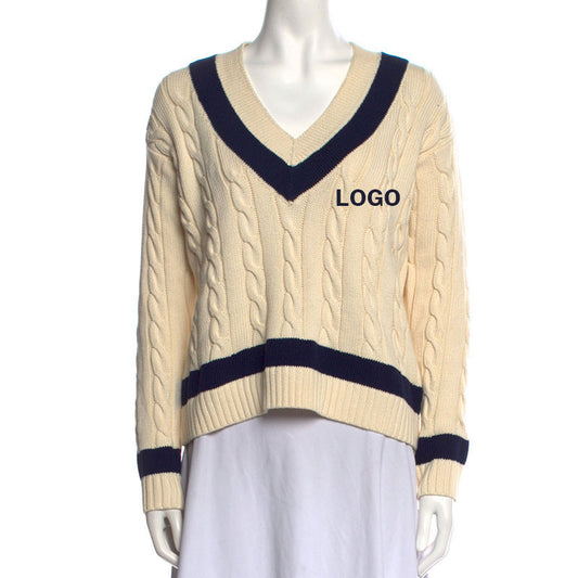 Front view of a cream-colored 100% cotton women's knit pullover sweater with a V-neck, navy blue accents, cable knit pattern, and custom logo on the chest.