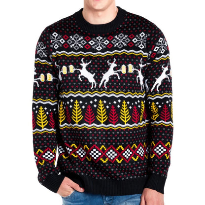 Front view of a festive ugly Christmas sweater featuring reindeer, snowflakes, and colorful patterns in black, red, yellow, and white. The model is wearing the sweater paired with jeans.