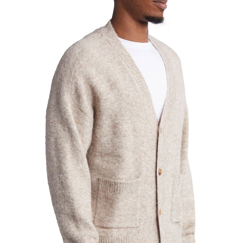 Side view of a model showcasing the custom wool blend knit cardigan with a front pocket design.