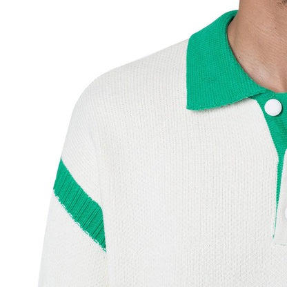 Close-up of the white 100% cotton pullover knit sweater with green color block design, focusing on the polo collar and button placket detail.