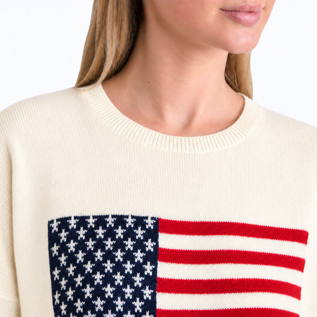 Close-up of American flag chest graphic on cream sweater